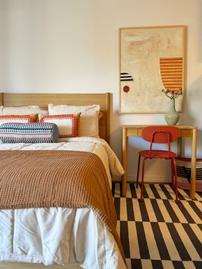 Kissimmee apartment for rent - A bed with a brown blanket and a red chair in front of a painting at The Teale Siesta Lago in Kissimmee, FL, 34746