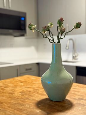 Kissimmee apartment for rent - A green vase with flowers on a wooden table in a kitchen at The Teale Siesta Lago in Kissimmee, FL, 34746