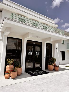 Kissimmee apartment for rent - The front of a white building with a black door and windows. at The Teale Siesta Lago in Kissimmee, FL, 34746