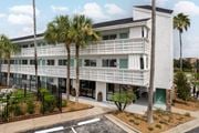 Kissimmee apartment for rent - a large white building with palm trees in front of it at The Teale, Kissimmee, FL, 34746