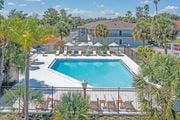 Kissimmee apartment for rent - a swimming pool with chairs around it and a building in the background at The Teale, Kissimmee, FL, 34746