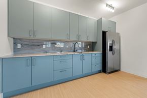 Melbourne apartment for rent - A kitchen with blue cabinets and a black refrigerator.