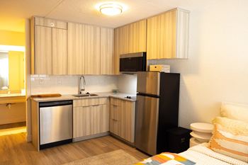 A small kitchen with a refrigerator and sink in a hotel room