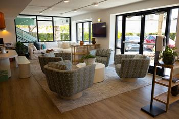 A living room with couches and chairs and a tv