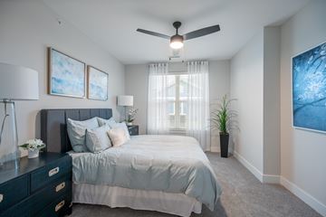 Mason apartment for rent - A bedroom with a bed, dresser, and ceiling fan.