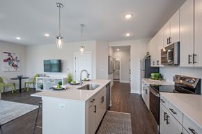 Mason apartment for rent - A modern kitchen with white cabinets and a large island.