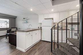East Lansing apartment for rent - A kitchen with white cabinets and a black railing.