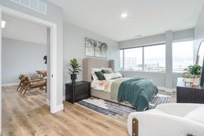 Troy apartment for rent - A bedroom with a bed, a chair, and a plant.