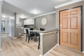 Okemos apartment for rent - A kitchen with a table and chairs and a clock on the wall.