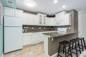 East Lansing apartment for rent - A kitchen with white cabinets and a white fridge.