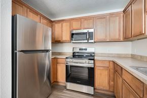 Brighton apartment for rent - A kitchen with a stainless steel refrigerator, microwave, oven, and cabinets.