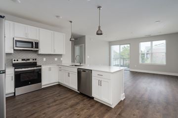 Okemos apartment for rent - A modern kitchen with white cabinets and stainless steel appliances.