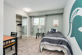 East Lansing apartment for rent - A bedroom with a bed, a chair, and a desk.