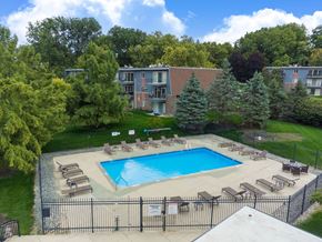 Grand Rapids apartment for rent - A pool surrounded by trees and chairs.