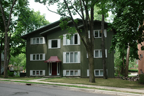 East Lansing apartment for rent - A green building with a red awning sits on a street.