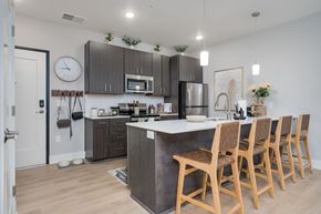 Brighton apartment for rent - A kitchen with wooden chairs and a white counter.