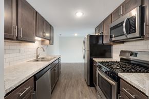 Grand Rapids apartment for rent - A modern kitchen with dark wood cabinets and stainless steel appliances.