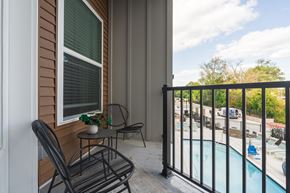 Brighton apartment for rent - A balcony with a table and chairs overlooking a pool.