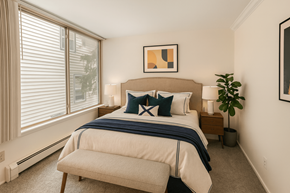 East Lansing apartment for rent - A bedroom with a large bed and a window with blinds.