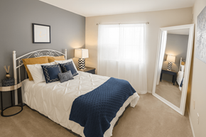 Comstock Park apartment for rent - A bedroom with a white bed and blue bedding.