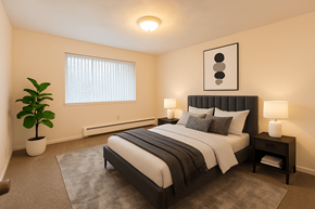 Lansing apartment for rent - A bedroom with a large bed and a potted plant.