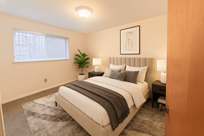 Lansing apartment for rent - A bedroom with a large bed and a window.