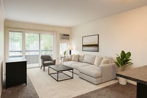 East Lansing apartment for rent - A living room with a grey couch, a black cabinet, and a coffee table.
