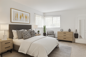 East Lansing apartment for rent - A bedroom with a large bed, a nightstand, and a dresser.
