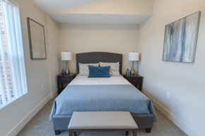 East Lansing townhouse for rent - A bedroom with a large bed and a painting on the wall.