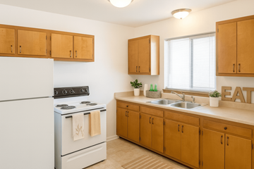 East Lansing apartment for rent - A kitchen with wooden cabinets and a white refrigerator.