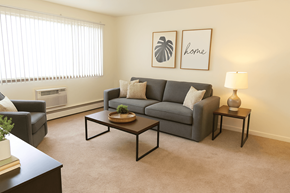 East Lansing apartment for rent - A living room with a grey couch, a black coffee table, and a lamp.