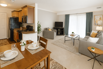 East Lansing apartment for rent - A well-lit, modern living room with a dining table set for two.