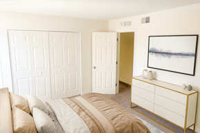 East Lansing townhouse for rent - A bedroom with a bed, a dresser and a painting on the wall.