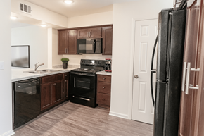 East Lansing townhouse for rent - A kitchen with a black refrigerator and brown cabinets.
