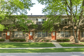 East Lansing townhouse for rent - A building with a green tree in front of it.