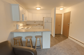 East Lansing apartment for rent - A kitchen with white appliances and wooden stools.