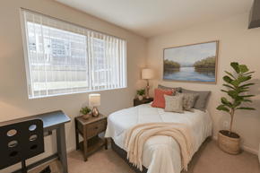 East Lansing apartment for rent - A bedroom with a bed, desk, chair, and a painting on the wall.
