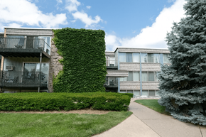 East Lansing apartment for rent - A building with a green hedge on the side.
