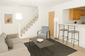 East Lansing apartment for rent - A living room with a grey couch, a blue chair, and a black coffee table.