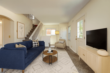 East Lansing apartment for rent - A living room with a blue couch and a television.