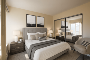 East Lansing apartment for rent - A bedroom with a large bed, a chair, and a mirror.