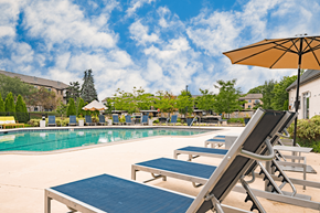 Ann Arbor apartment for rent - A sunny day at the pool with lounge chairs and umbrellas.