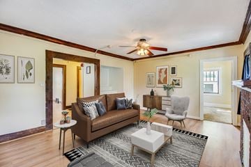 East Lansing apartment for rent - A living room with a brown couch and a ceiling fan.