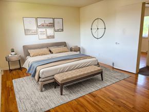 Lansing townhouse for rent - a bedroom with a bed and a clock on the wall
