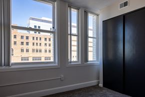Detroit apartment for rent - room with three windows and a door and a view of a building