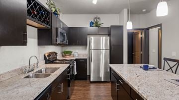Grand Rapids apartment for rent - A modern kitchen with dark cabinets and a stainless steel refrigerator.