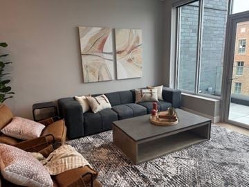 Royal Oak apartment for rent - A living room with a grey couch, a coffee table, and a painting on the wall.