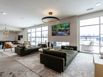 Haslett apartment for rent - A living room with a large couch and a television mounted on the wall.