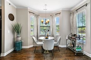 Ada apartment for rent - a dining room with three windows and a table and chairs