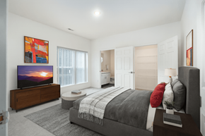 Lansing apartment for rent - A bedroom with a large bed and a flat screen TV.